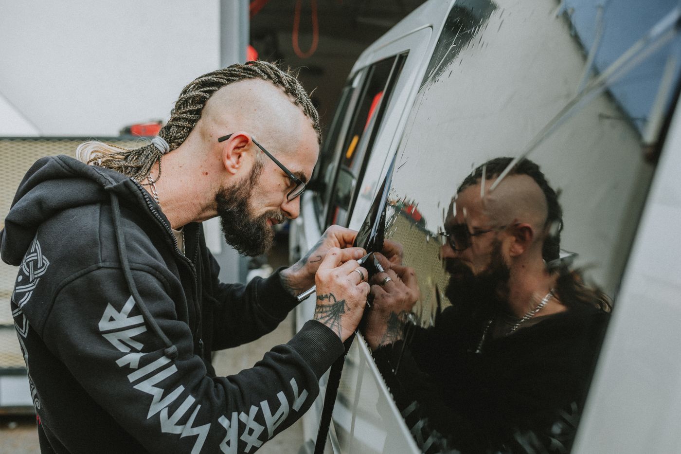 Technician carefully applying tint film to a vehicle window